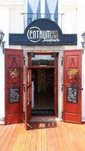 - l'entrée d'un restaurant avec des portes rouges et un panneau dans l'établissement Centrum Panzió, à Szentendre