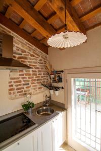 - une cuisine avec un évier et un mur en briques dans l'établissement B&B La Porta Rossa, à Noale