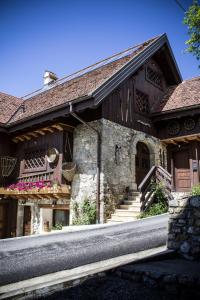 a stone building with stairs and flowers on it at Albergo Diffuso Zoncolan in Ovaro