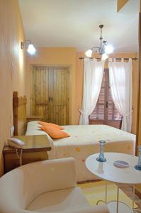 a bedroom with two beds and a table at Hotel Posada Casas Viejas in Benalup Casas Viejas