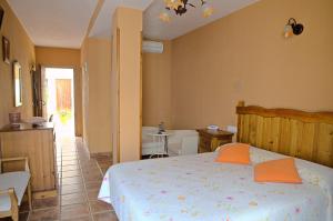 a bedroom with a bed with orange pillows on it at Hotel Posada Casas Viejas in Benalup Casas Viejas