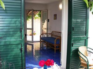 Habitación con puertas verdes y porche con banco. en Villa Verdemare Naxos, en Giardini Naxos