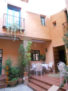 un patio con mesas y sillas frente a un edificio en Hotel Casa Rural San Antón en Chinchón