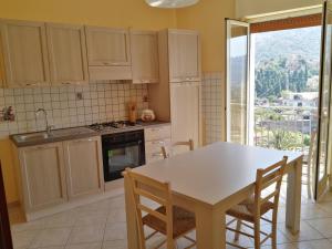 eine Küche mit einem Tisch und Stühlen sowie einem Fenster in der Unterkunft Casa Catena in Francavilla di Sicilia