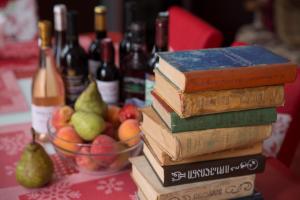 a stack of books on a table with pears and bottles of wine at Guesthouse Medea on Pushkini 4 in Kutaisi