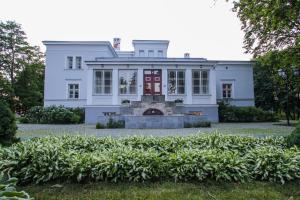 una grande casa bianca con una porta rossa di Saka Manor a Saka