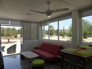 a living room with a red couch and a table at Casa Jardin in Agua Amarga