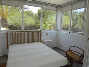 a bedroom with a bed and two windows at Casa Jardin in Agua Amarga