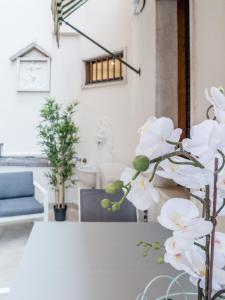
a white vase filled with flowers on top of a table at Luxury Apartment On Grand Canal in Venice
