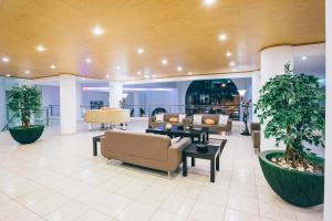 a lobby with couches and tables and plants at Grand Muthu Forte do Vale in Albufeira