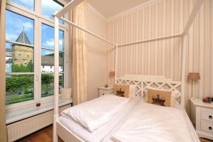 a bedroom with a white bed and a large window at Hotel Bucheneck in Linz am Rhein