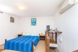 a small bedroom with a bed and a desk at Apartments Islandbreeze in Prvić Šepurine