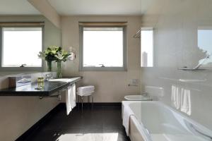 uma casa de banho com uma banheira, um lavatório e um WC. em Eurostars Lucentum em Alicante