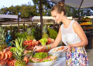 a woman holding a plate of food at a market at Martı Myra - Ultra All Inclusive in Tekirova