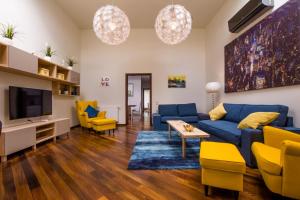 a living room with a blue couch and yellow chairs at Apart Madryt in Tarnobrzeg