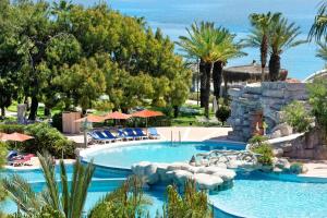 a pool at a resort with chairs and trees at Martı Myra - Ultra All Inclusive in Tekirova