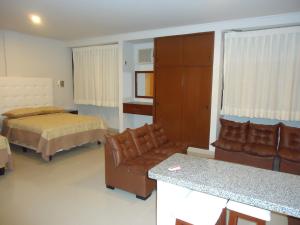 een hotelkamer met een bed en een bank en een bed en een kamer bij Gran Hotel Canada in Santa Cruz de la Sierra