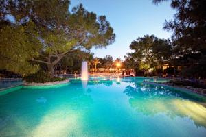 a swimming pool with a fountain at night at Martı Myra - Ultra All Inclusive in Tekirova