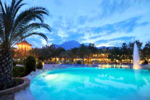 a swimming pool at night with a fountain at Martı Myra - Ultra All Inclusive in Tekirova