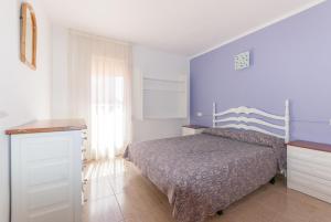 - une chambre avec un lit et un mur bleu dans l'établissement Apartaments Fincasol, à L'Estartit