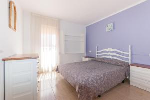 a bedroom with a bed and a blue wall at Apartaments Fincasol in L'Estartit