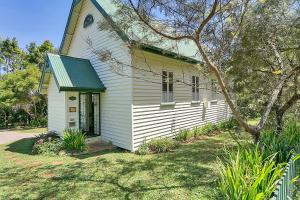 a small white church with a green roof at The Church in Yungaburra