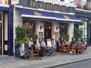 a group of people sitting at tables outside a restaurant at Julian apartment center of London in London
