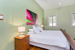 a bedroom with a bed and a painting on the wall at The Church in Yungaburra
