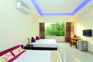 a hotel room with two beds and a television at Royal Homestay in Hoi An +23 photos