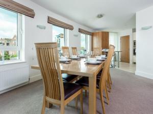 a dining room with a wooden table and chairs at Panorama in Poole