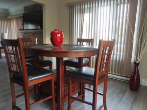 een rode vaas op een houten tafel met stoelen bij Casa Bella in Gatineau