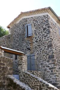 Edificio de piedra con 2 ventanas y balcón en Domaine de Chabanet en Privas