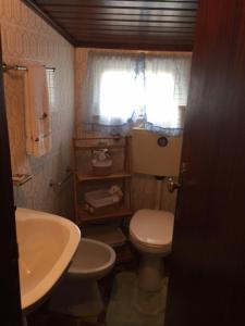 a bathroom with a white toilet and a sink at Casa da Avó in Geres