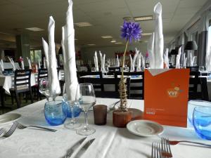 una mesa con un mantel blanco con copas de vino en VVF Le Lioran Les Monts du Cantal, en Saint-Jacques-des-Blats