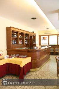 un vestíbulo de hotel con 2 mesas y un bar en Hotel Ducale, en Vigevano