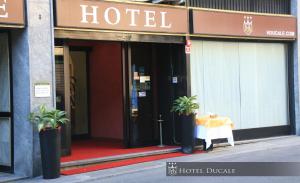 ein Hotelgebäude mit einem Tisch davor in der Unterkunft Hotel Ducale in Vigevano