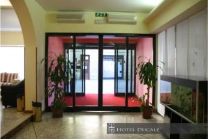 an open door in a lobby with potted plants at Hotel Ducale in Vigevano