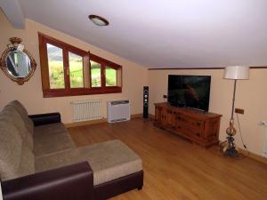 a living room with a couch and a flat screen tv at Elai Etxea Loft Baias in Pobes