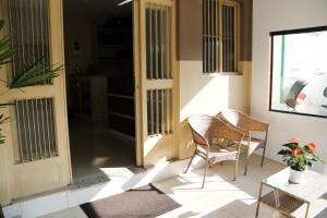 a porch with two chairs and a table and a door at Hotel Vale das Artes in Embu