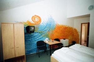 una stanza con una camera da letto con un letto e un tavolo di Motel Dacice a Dačice