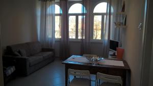 un soggiorno con divano, tavolo e sedie di Apartment Roma a Borgo Val di Taro