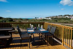 una terraza de madera con mesa y sillas. en Dibiki Holiday Resort, en Hartenbos