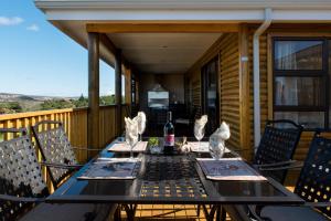 una mesa en una terraza con una botella de vino en Dibiki Holiday Resort en Hartenbos