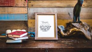 un cadre photo assis sur une table avec des livres dans l'établissement Off Beat Guesthouse - Self-check-in - Sleep Conscious, à Saint-Sébastien