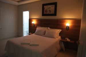 sypialnia z łóżkiem z dwoma ręcznikami w obiekcie Hotel das Torres w Guanambi