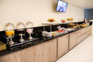 a buffet line in a hotel room with food at Hotel Vale das Artes in Embu