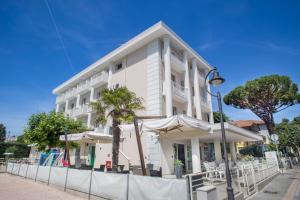 a white building with umbrellas in front of it at Hotel Bella Igea in Bellaria-Igea Marina