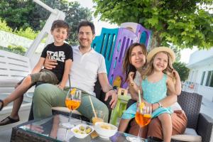 a family sitting on a patio with drinks at Hotel Bella Igea in Bellaria-Igea Marina