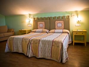 a bedroom with a large bed and two night stands at Posada Playa de Langre in Langre