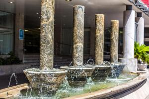 eine Reihe von Wasserbrunnen vor einem Gebäude in der Unterkunft Leonardo Hotel Granada in Granada